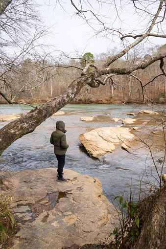 A man is enjoying the breath taking view of Chattahoochee River. Unexpected cold or hot weather is affecting the world. Tropical areas are suffering from drought while temperate areas are suffering from colder climate.