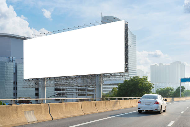 istock A white car is driving down a highway next to a large billboard. The billboard is white and blank, clipping path with no writing on it. 2149903698