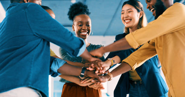 Teamwork, employees and hands with smile for support, group and collaboration for motivation with businesspeople. Team building, career and goals in office, partnership or cooperation in workplace