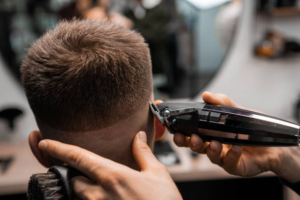 istock Master trims client hair with professional tool in shop 2149904622