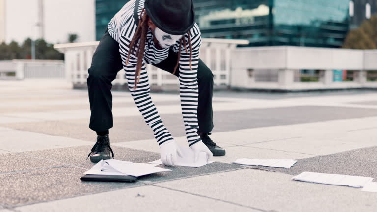 Man, walking and fall as street mime or performer with paper for circus and performance in downtown New York. Outdoor, comedy and funny on costume or face paint as artist for stunt with paperwork.