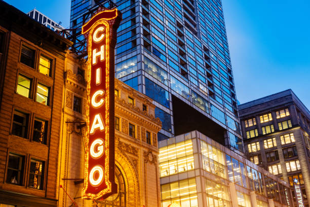 At dusk the landmark Chicago Theater is illuminated with cars driving past in a streak of motion blur with a long exposure.