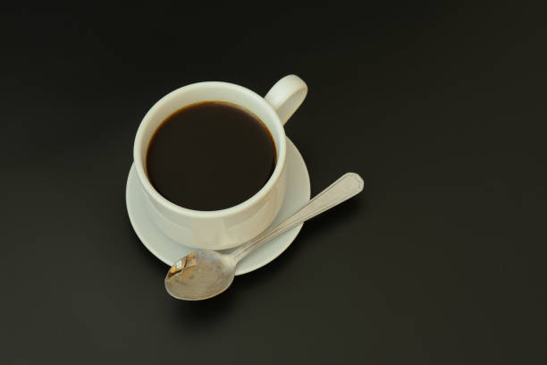 Green designer cup of creamy coffee isolated with a reflection in the foreground.