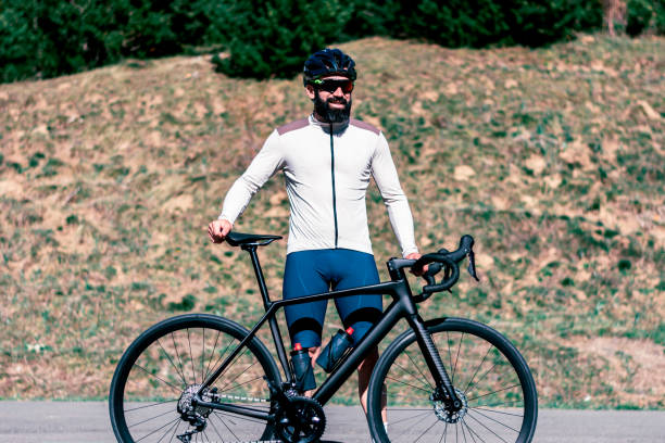 istock A man in an white-brown shirt stands next to a black bicycle 2149908991