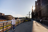 Senior woman tourist taking photos on the bridge at Steelstacks in Bethlehem, PA at sunset