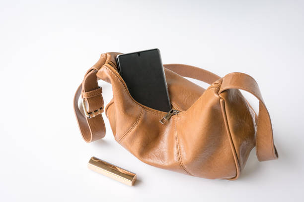 istock Woman leather handbag with phone and lipstick on table. 2149911349