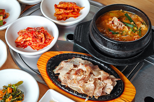 Korean grilled sliced meat and soy bean paste soup with side dishes. HIgh angle view.