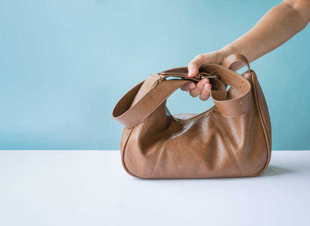 Woman holding a brown leather bag.
