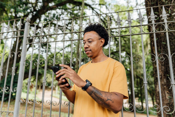 istock Young man using smartphone in city park 2149912107