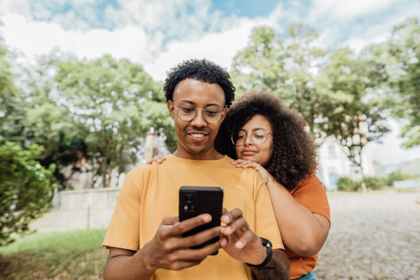 istock Couple sharing smartphone in city park 2149912128