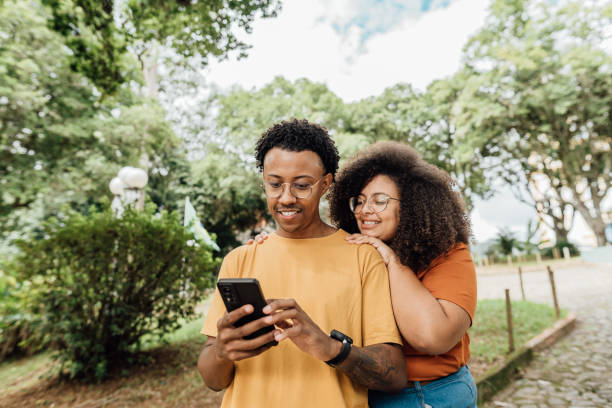 istock Couple sharing smartphone in city park 2149912133