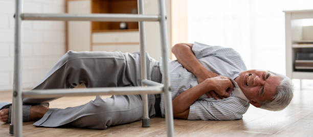 istock Asian senior elderly male fall on the ground while walk alone in house. Mature older grandfather having an accident and fainting while doing physical therapy after retirement in living room at home. 2149913190