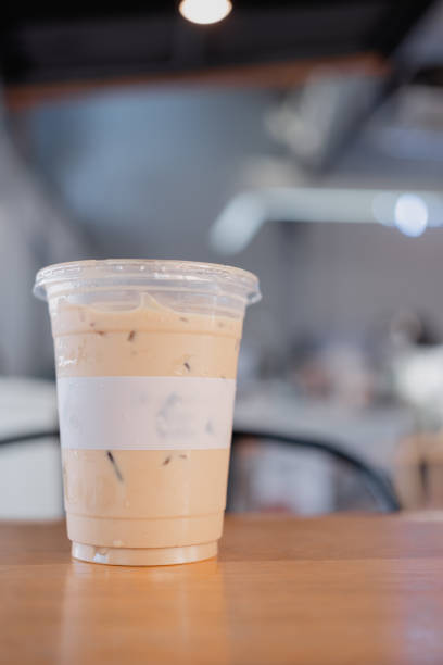 Iced latte coffee in plastic takeaway glass. Summer refreshment concept. Front view.