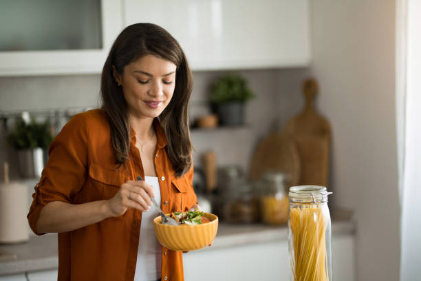 istock Woman preparing and tasting a salad at home. 2149914966