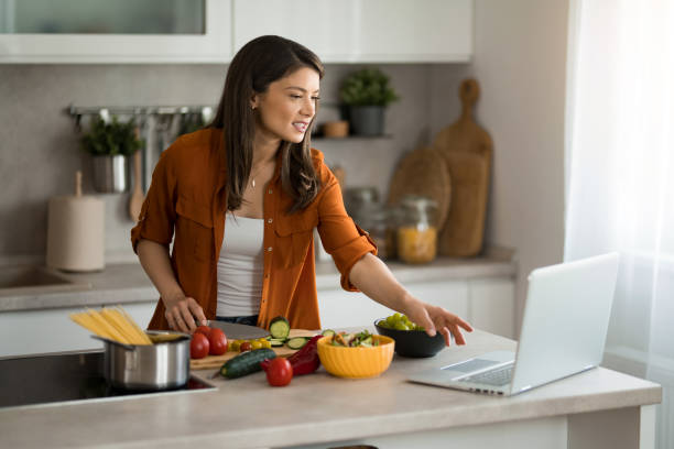 istock Woman preparing food in the kitchen while looking for tips online. 2149915924