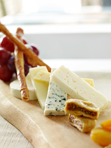 Cheese plate full of variety of gourmet cheeses on restaurant table