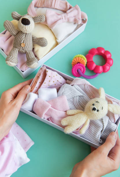 istock Women's hands collect children's clothes into boxes. 2149917878