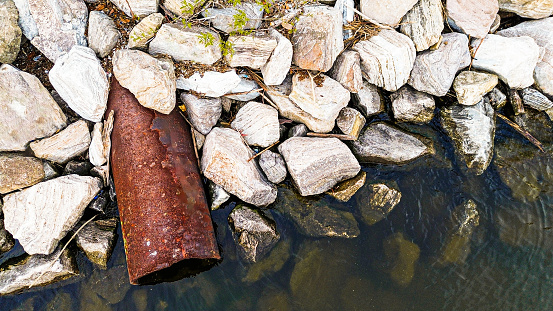 View of a drain pipe alongside rocks in Baltimore