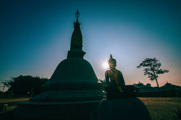 Silhouette buddha statue sitting in meditation.