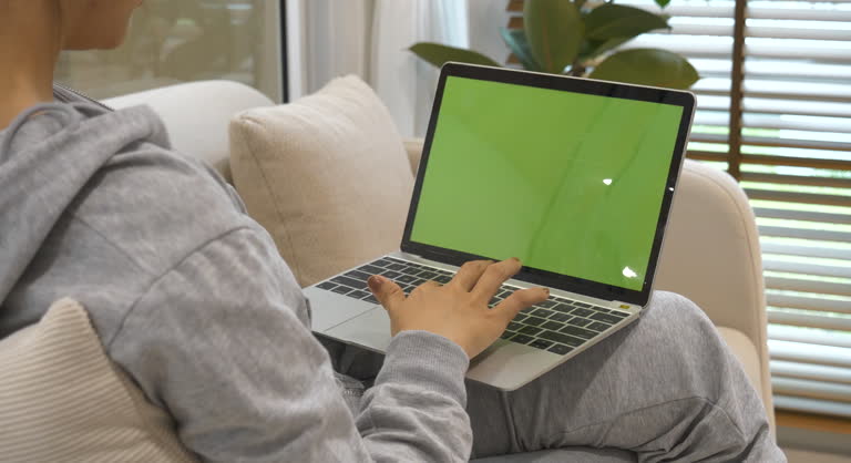Empty Green Screen laptop Blogger Woman hands typing Laptop computer keyboard. Close up women hands using laptop sitting sofa living room. Freelance women work from home office video call conference