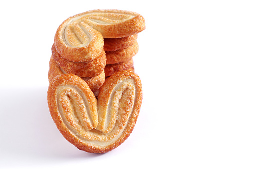 Stack of palmier puff pastry cookies on a white background. Space for text