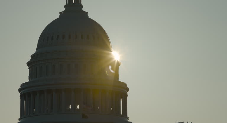 U.S. Capitol Dome in Silhouette with Sunburst Beginning to Show