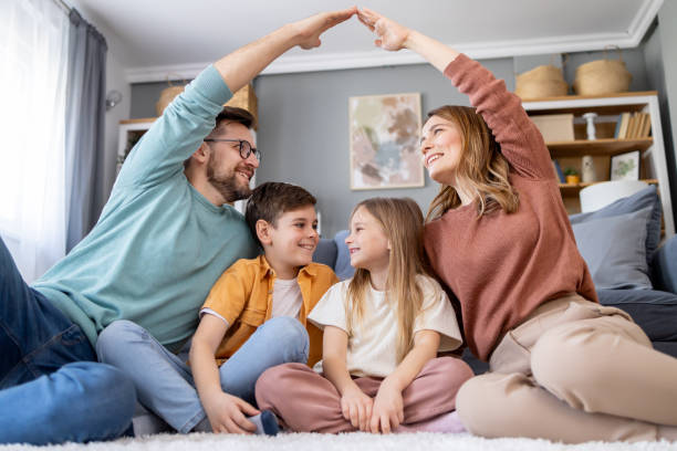 Joyful family forming a house shape with hands