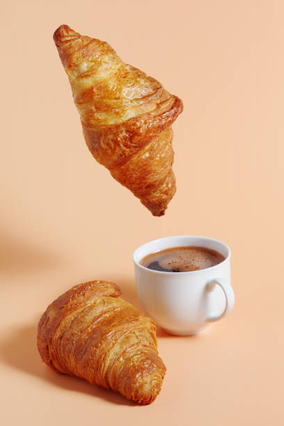 istock Croissant hanging over coffee 2149923947