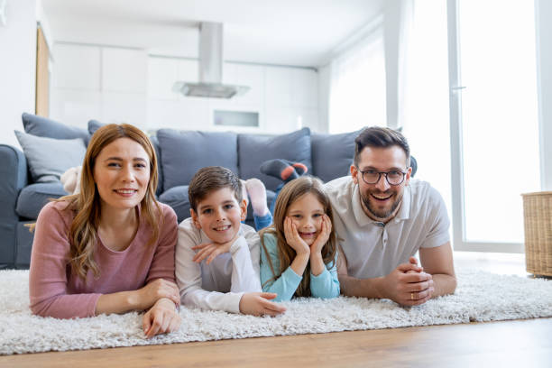 istock Family lying on floor smiling at camera 2149924235