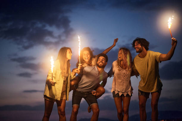 istock Cheerful friends having fun with flaming torches by night. 2149924321