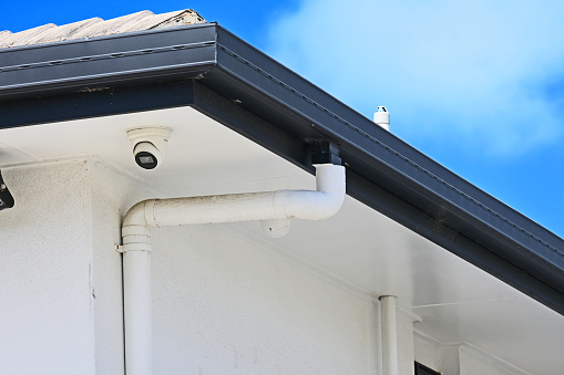 Roof gutter and downpipe on the corner of a house