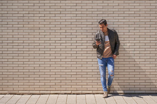 istock Handsome man texting on phone while waiting on the street 2149927233
