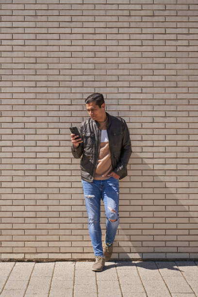 istock Handsome man texting on phone while waiting on the street 2149927249