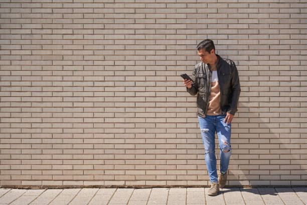 istock Handsome man texting on phone while waiting on the street 2149927255