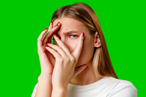 Young Woman Covering Her Face With Hands against green background