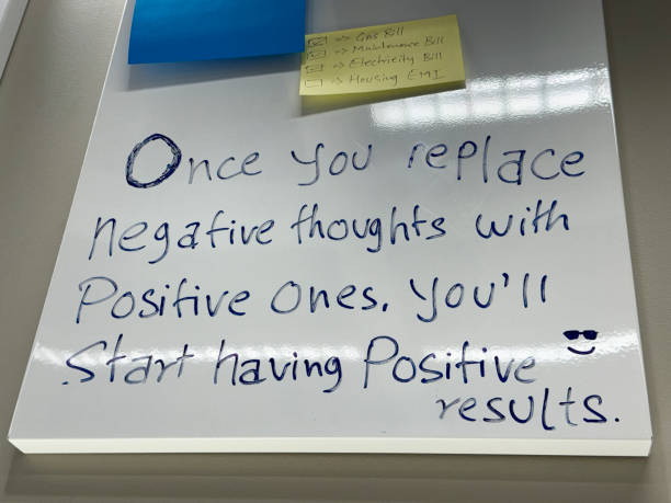 istock Close-up image of rectangular, yellow sticky note stuck on whiteboard, check list of bills needing to be paid, checkboxes with and without check marks, motivational quote written in non-permanent ink marker, focus on foreground 2149928161