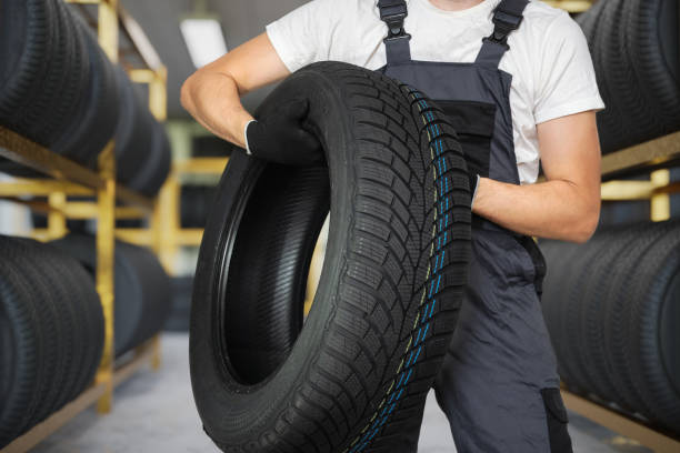 istock Car mechanic is holding winter tire in hands. 2149928742
