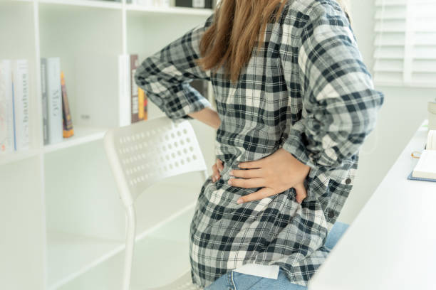 istock woman holding her lower back while and suffer from unbearable pain health and problems, chronic back pain, backache in office syndrome, scoliosis, herniated disc, muscle inflammation 2149930103
