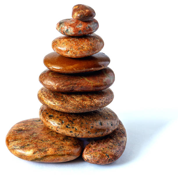 Brown sea pebbles pyramid tower of different shapes on white background isolated
