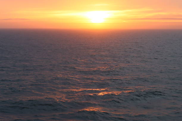 Dawn at sea, with waves tinged with golden sunlight