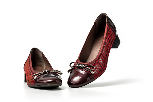 Studio photo of brown female loafers with low heel. Slip on female leather brown shoes on white background