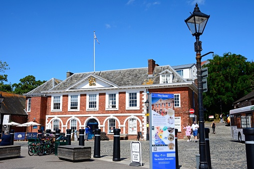 Front view of the Custom House (now a visitor centre) along the waterfront with an information sign in the foreground, Exeter, Devon, UK, Europe.