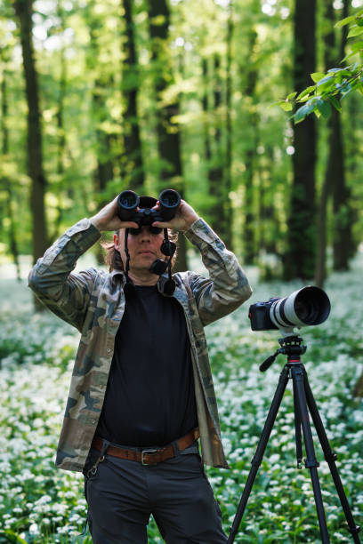 istock Wildlife photographer is bird watching in forest 2149934327