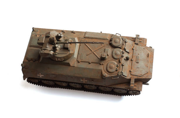 Armored plastic tank toy on red fabric.