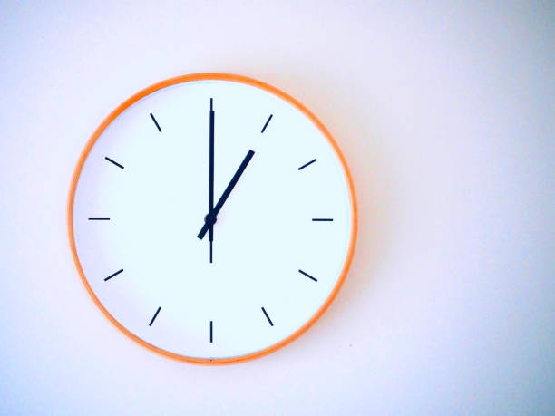 istock minimal wall clock on white show 13.00, 1.00 2149939231