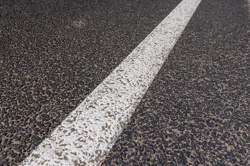 white line on an asphalt highway, details of a highway with a white painted line