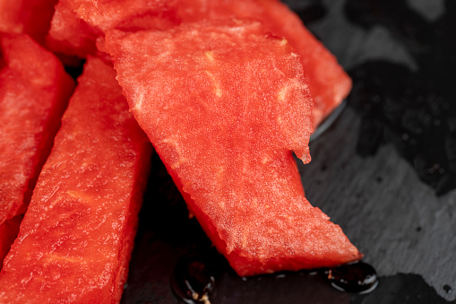 sliced into pieces of red ripe watermelon, the pulp of a ripe watermelon of red color lies on the table