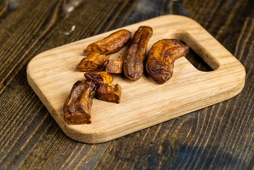 small dried bananas on a board, dried fruits made from dehydrated but soft dried bananas