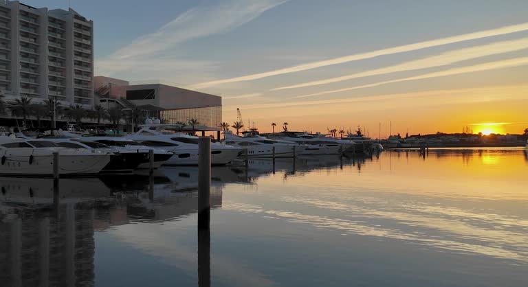 A 4k static shot of Chem trails reflected in the Villamoura Marina Water at sunset