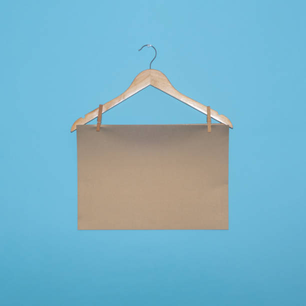 istock Brown paper on a hanger creative concept with copy space on a blue background. 2149941744